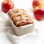apple cinnamon bread loaf sliced on wooden board